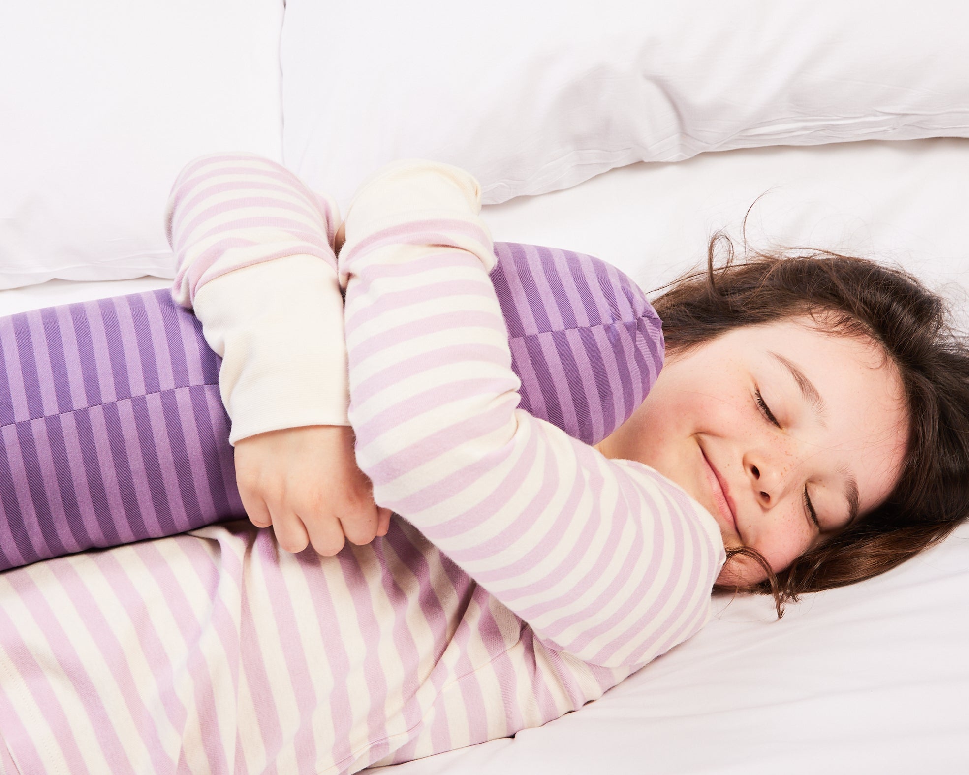 A young girl fell asleep hugging her weighted short pillow