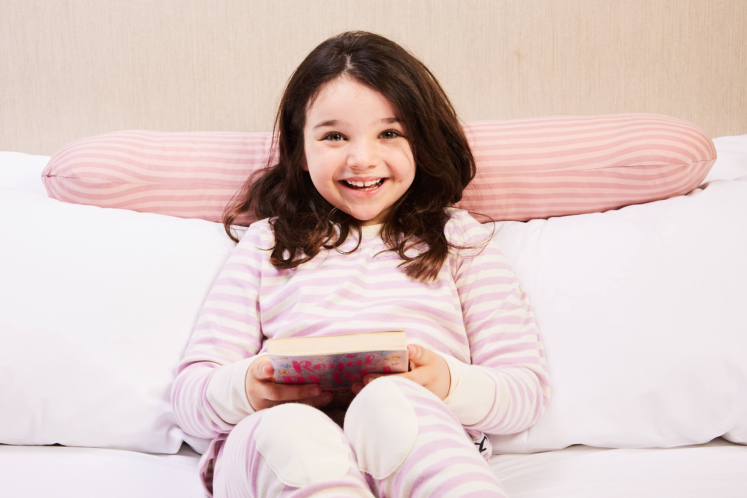 Young girl happily using her pink weighted sleep pillow