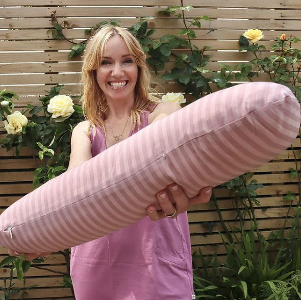 Weighted sleep pillow being held by a happy women