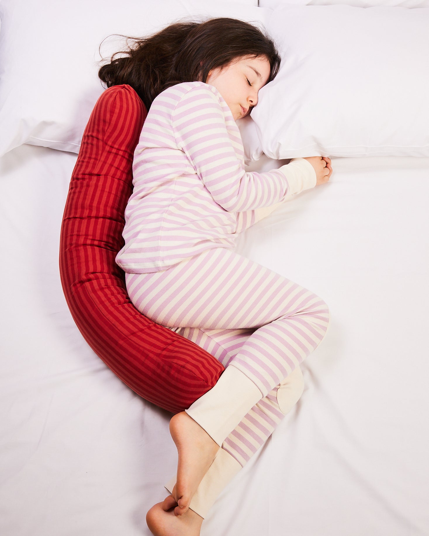 Young girl sleeping with the red weighted pillow