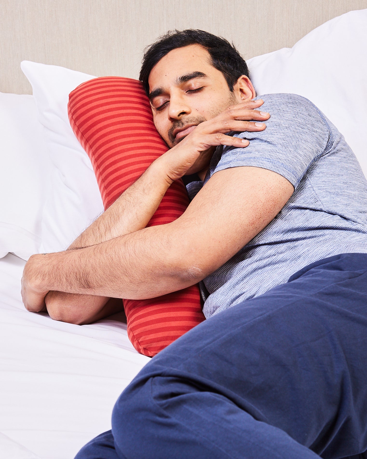Adult male hugging his weighted short pillow for better sleep